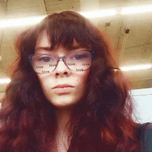 a woman wearing glasses has the word love on her face