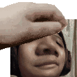 a hand is touching a woman 's face while wearing headphones .
