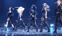 a group of women are dancing on a stage and one of them is holding a microphone