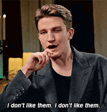 a man in a suit is talking and saying `` i don 't like them , i don 't like them .