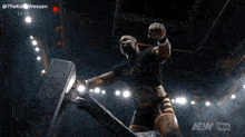 a man in a wrestling ring with the aew logo on the bottom