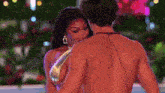 a man and a woman are dancing in a pool . the woman is wearing a bikini .