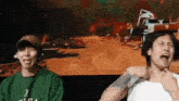 two men are sitting next to each other in front of a screen .