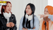 three girls are standing next to each other and one of them is wearing a blue shirt with the number 8 on it