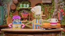 two stuffed animals wearing chef hats and aprons are standing in front of a sign that says " welcome "