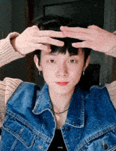 a young man wearing a denim jacket and a necklace with the word energy on it