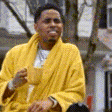 a man in a yellow robe is drinking from a cup