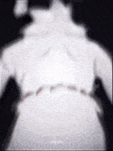 a blurred image of a person 's back with a white shirt on .