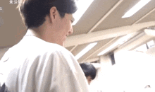 a man in a white shirt looks over his shoulder