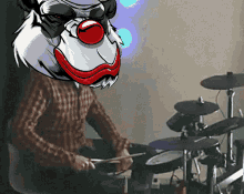 a man playing drums with a clown 's head behind him