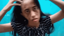 a woman with bruises on her face is holding her hair .