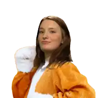a woman wearing an orange fur coat and white gloves looks at the camera