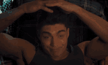 a man is laying on a bed with his arms behind his head