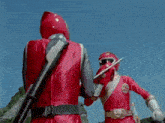 two red rangers are fighting each other with swords in a cartoon .