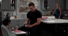 a man is feeding a little girl in a high chair