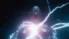 a man is being struck by lightning while standing in a dark room .
