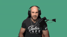 a man wearing headphones and a claudio 's cafe shirt