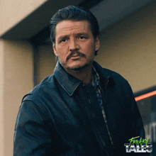 a man with a mustache is standing in front of a building with freaky tales written on the bottom