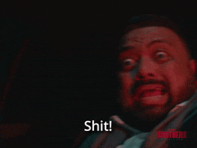 a man with a beard is screaming with the word shit in front of him