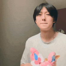 a young man is holding a stuffed animal in his hands .
