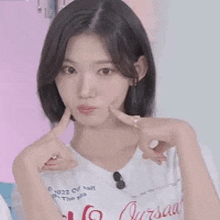 a young woman is making a heart with her hands .