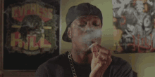 a man smoking a cigarette in front of a poster that says express hill