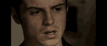 a close up of a man 's face with his mouth open and a serious look on his face .
