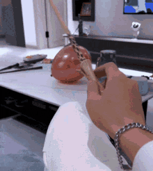 a person sitting on a couch with a bracelet on their wrist holding a balloon