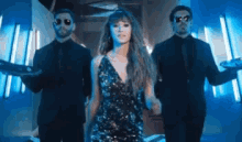 a woman in a sequined dress is surrounded by men in suits