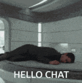 a man laying on a bed with the words hello chat written above him