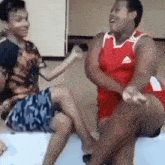 a group of people are sitting on a couch laughing and having fun .