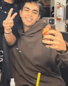 a young man is taking a selfie in front of a mirror .