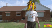 a man wearing a shirt that says dumpster dorks is standing in front of a brick house