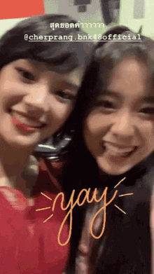 two girls are posing for a picture and one of them has the word yay written on it