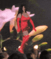 a woman in a red dress and gloves is standing on a flower