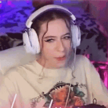 a woman is wearing headphones and making a funny face while sitting in a chair .