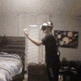 a man wearing a virtual reality headset stands in a bedroom