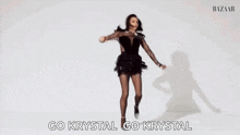 a woman is dancing in a black dress and tights .