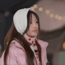 a girl wearing a pink jacket and a white scarf