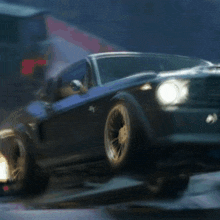 a blue car with the headlights on is driving down the road