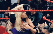 a woman is being held by a man in a wrestling ring ..