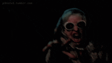 a person wearing sunglasses screams in the dark