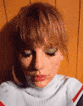 a close up of a woman 's face wearing a turtleneck sweater and earrings .