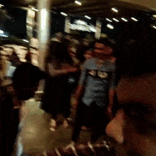 a blurry photo of a group of people walking in a dark room