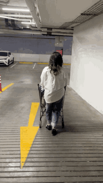 a woman pushing a shopping cart down a wooden ramp