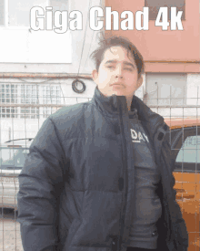 a young man wearing a black jacket stands in front of a fence with the words giga chad 4k above him