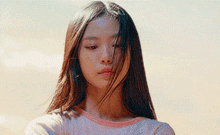 a close up of a woman 's face with long hair blowing in the wind