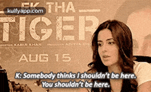 a woman is sitting in front of a poster for the movie tiger