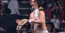 a woman in a wrestling outfit is holding a belt with the aew logo on the bottom