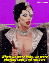 a drag queen is holding a cigar and says when we were kids we were playing cops and robbers .